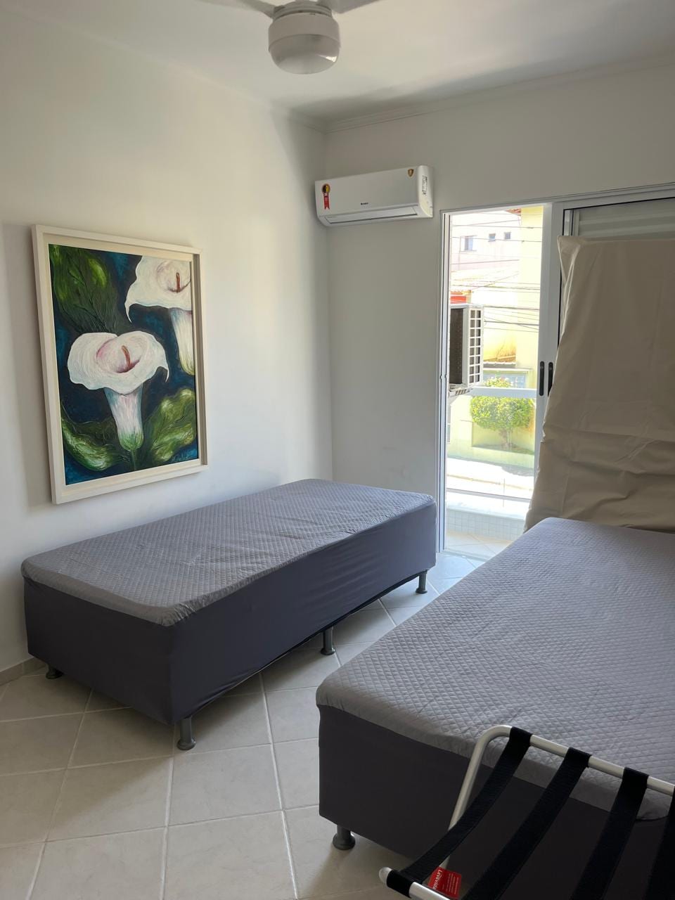 Segundo quarto com duas camas de solteiro e ar-condicionado